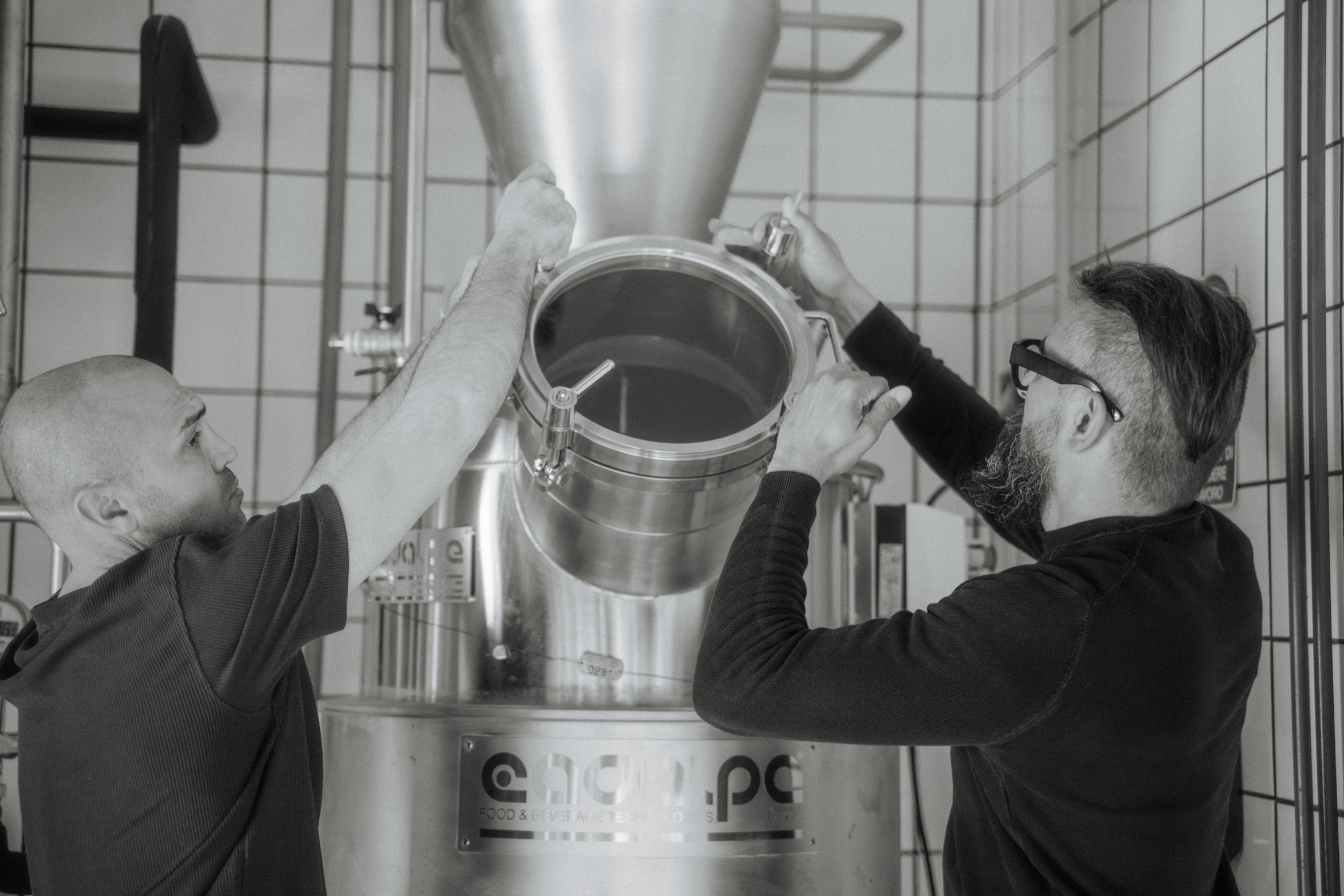 Two distillers at work on the still in the Distilleria Fornillo still house